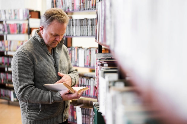 focused-senior-man-looking-book (1)